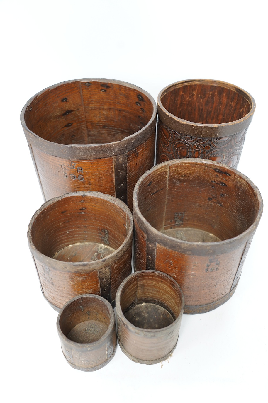 A matched set of five early 20th century iron bound bushel measures, one peck to half pint, together with a pressed card paper basket. Condition - fair to good